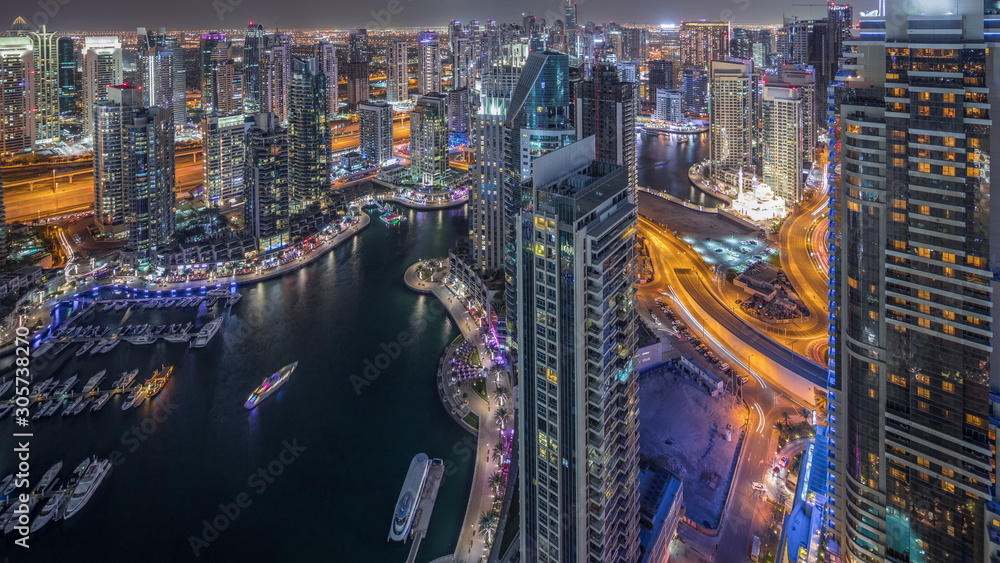 Fototapeta premium Dubai Marina skyscrapers and jumeirah lake towers view from the top aerial night timelapse in the United Arab Emirates.