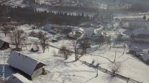 Aerial view to fairy-tale village Kryvorivnia covered with snow in the Carpathians winter mountains. Beautiful landscape at Hutsulshchyna National Park in Ukraine. Vacation and winter sports photo