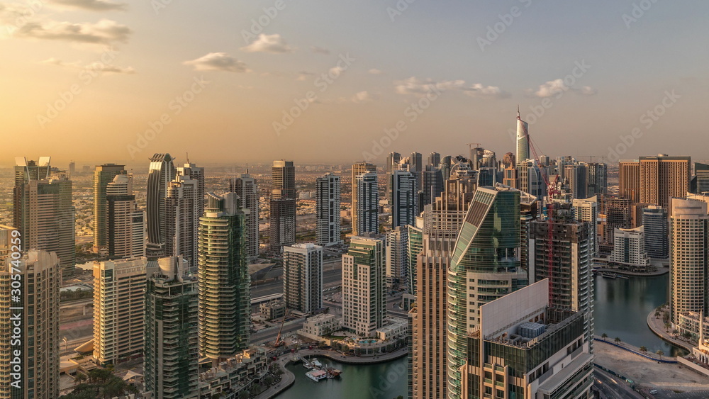 Dubai Marina skyscrapers and jumeirah lake towers sunrise view from the top aerial timelapse in the United Arab Emirates.