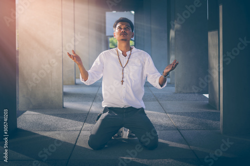 Fotografija Handsome young Asian wearing his rosary crucifix symbol