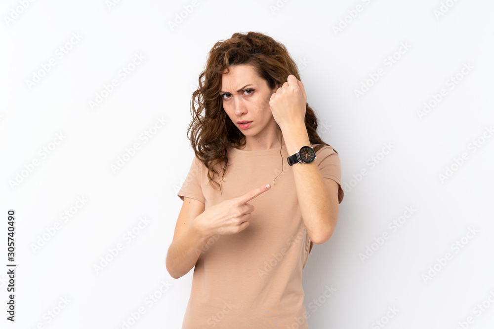 Young pretty woman over isolated background showing the hand watch with serious expression serious because it is getting late Young pretty woman over isolated background showing the hand watch with serious expression serious because it is getting late