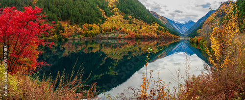 The mirror Reflection of the mountain and distant glacia at the Mirror Lake during autumn in Jiuzhaigou National Park, Sichuan, China. photo