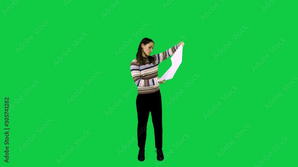 Girl opens up a poster in front of the green screen Girl opens up a poster in front of the green screen