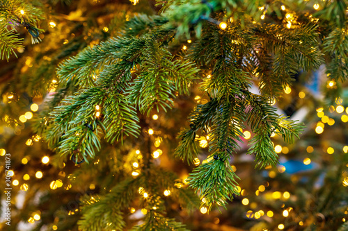 Outdoor decorated Christmas tree with light garland, selective focus