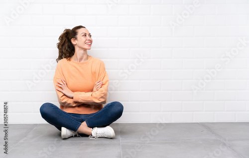 Young woman with curly hair sitting on the floor laughing Free Download Young woman with curly hair sitting on the floor laughing - GFXLoad