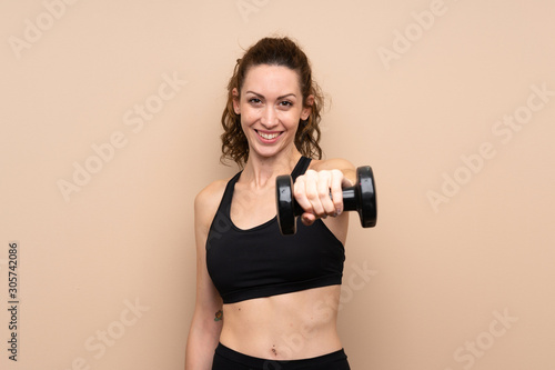 Young sport woman over isolated background making weightlifting