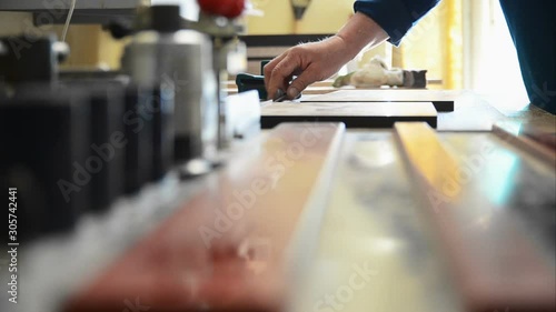 The master processes the edges of furniture blanks with a working knife, close-up