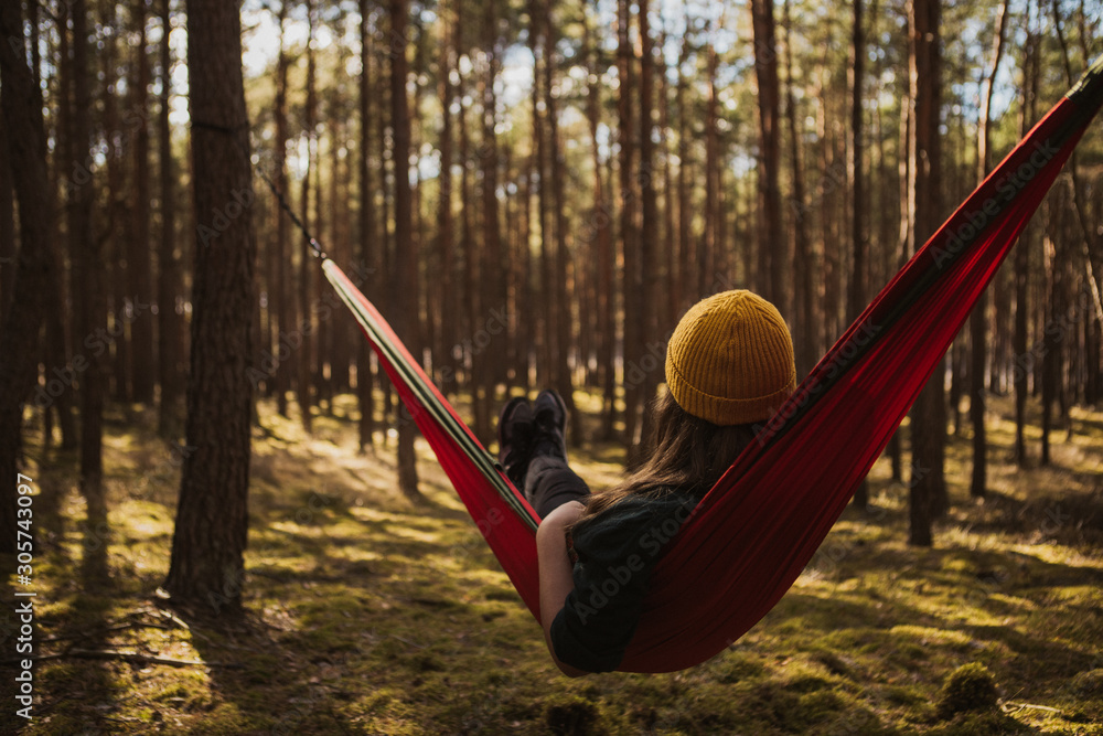 Beautiful young woman relaxing in hammock in forest. Summer scenery, a beautiful morning in the bosom of nature. The girl admires the views and nature. Breathed fresh air. Beautiful morning light. Beautiful young woman relaxing in hammock in forest. Summer scenery, a beautiful morning in the bosom of nature. The girl admires the views and nature. Breathed fresh air. Beautiful morning light.