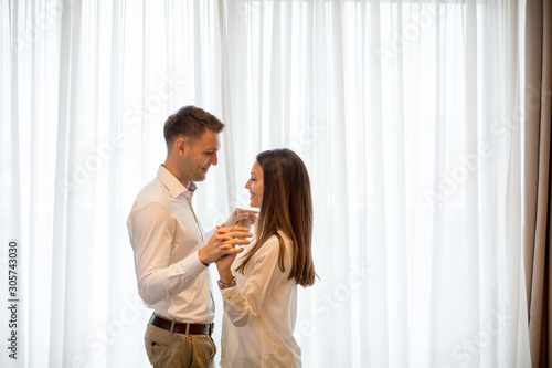 Young couple in love at home standing by the window and embracing