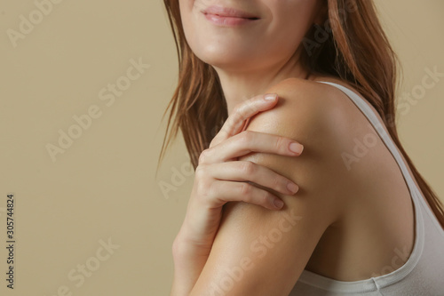 Woman applying body cream on arm, beauty skin care concept, studio shot