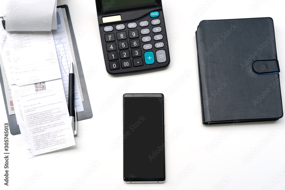 Office work table with bill, mobile phone, notebook and calculator on white table , Top view, copy space for text message Office work table with bill, mobile phone, notebook and calculator on white table , Top view, copy space for text message