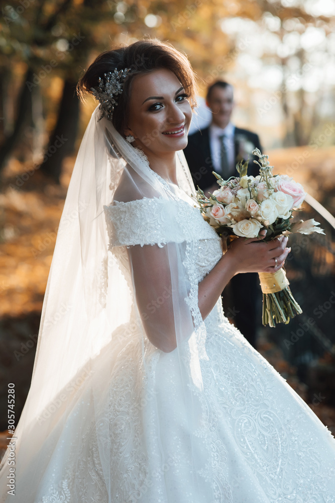 Young wedding romantic couple of bride in white dress and bridegroom in  suit standing in autumn deep forest outdoor on natural background. Married,  love, feelings, bridal bouquet. Autumn wedding Stock-Foto | Adobe