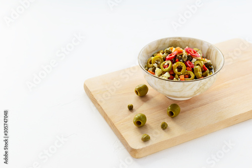 Olive salad for muffuletta in a bowl on a white table. photo