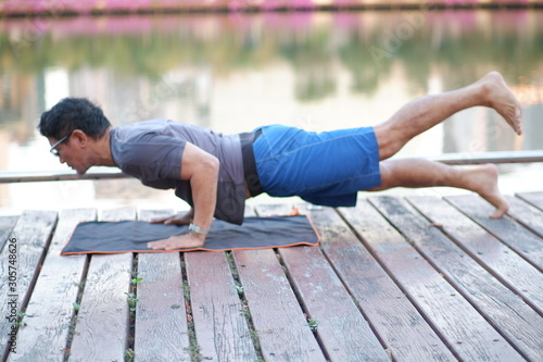 young couple sitting on a bench in the park​ doing your car exercise practice flexibility and balance strong body muscle