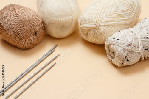 Woolen yarns for knitting. Balls of natural wool yarn and knitting needles.