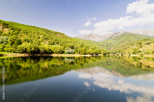 beautiful panoramic view of a lake surrounded by green mountains