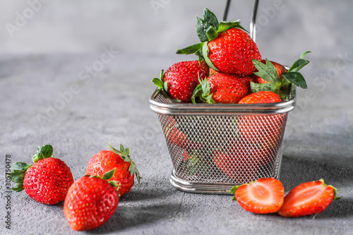 Photo of heap of fresh strawberries in the basket on rustic grey background..A bunch of ripe strawberries in a steel basket on the table. Copy space. Healthy fresh fruit. Organic food. Clear food