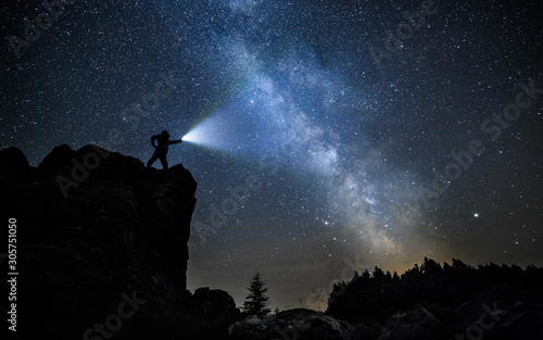 brave guy in night mountains alone with flashlight