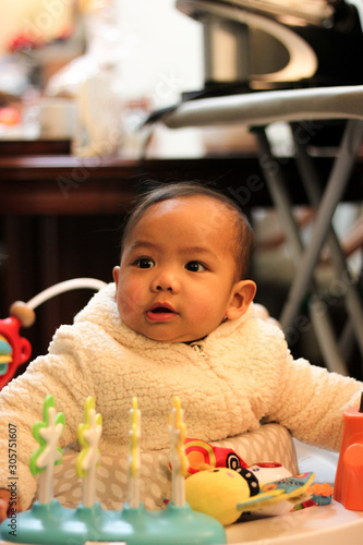 Asian baby dressed like a sheep playing with his toys