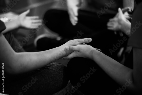 Black and white image with details of the hands of a little girl and a little boy playing.