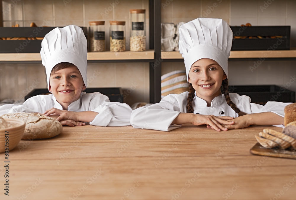Little bakers behind counter in kitchen Little bakers behind counter in kitchen