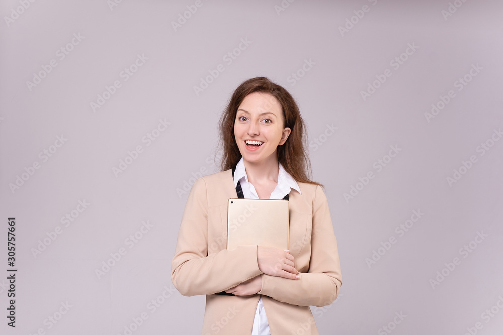 Successful ?aucasian positive elegant businesswoman in a beige jacket and holding a tablet in her hands posing on a purple background. Happy young woman advertises wholesales stores. Advertising space Successful ?aucasian positive elegant businesswoman in a beige jacket and holding a tablet in her hands posing on a purple background. Happy young woman advertises wholesales stores. Advertising space