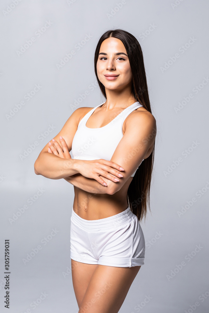 Smiling sports woman standing with arms folded and looking at camera isolated on white background Smiling sports woman standing with arms folded and looking at camera isolated on white background