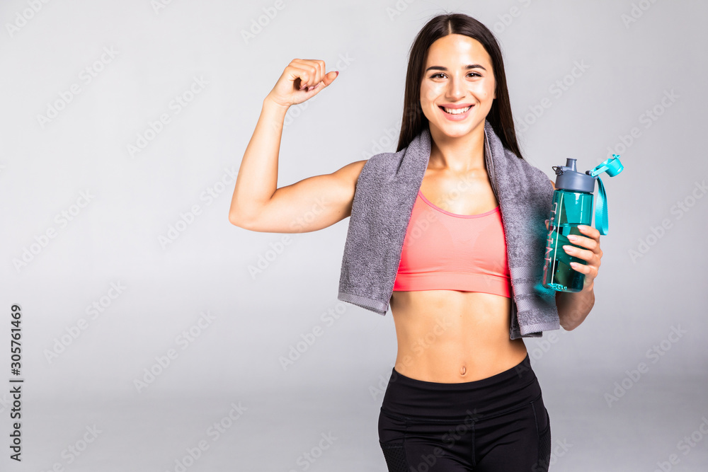 Portrait of fit healthy woman with gym towel and water bottle isolated on white background Portrait of fit healthy woman with gym towel and water bottle isolated on white background