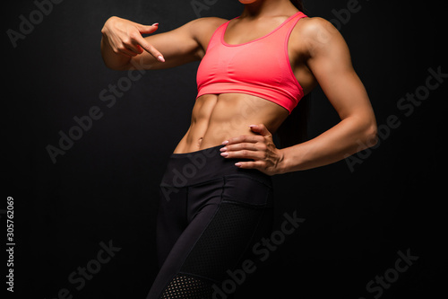 Cropped shot of a beautiful female with fit and toned strong body on black background.