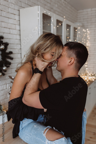 Romantic christmas evening of a young couple. New year love story. Photo session of lovers in the kitchen.