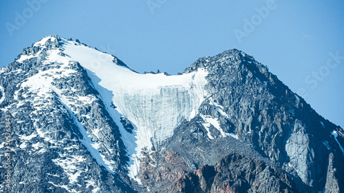 Snow cliffs under blue sky. Travel in mountains