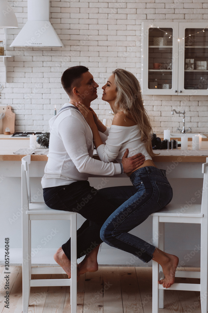 Romantic christmas evening of a young couple. New year love story. Photo session of lovers in the kitchen. Romantic christmas evening of a young couple. New year love story. Photo session of lovers in the kitchen.