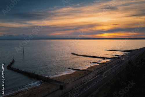 Fototapeta Naklejka Na Ścianę i Meble -  Sunset at the artificial beach of the western undercliff in Ramsgate, Kent, UK which has groins as water breakers.