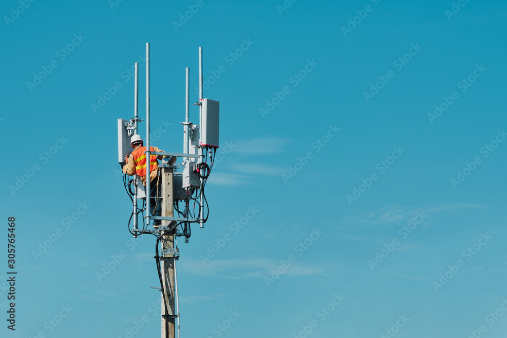 Technician on telecommunication antenna tower - obrazy, fototapety, plakaty 
