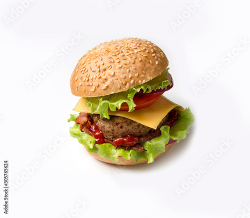 Homemade hamburger on white background. Hamburger with sesame seeds and bacon, greens and cheese.