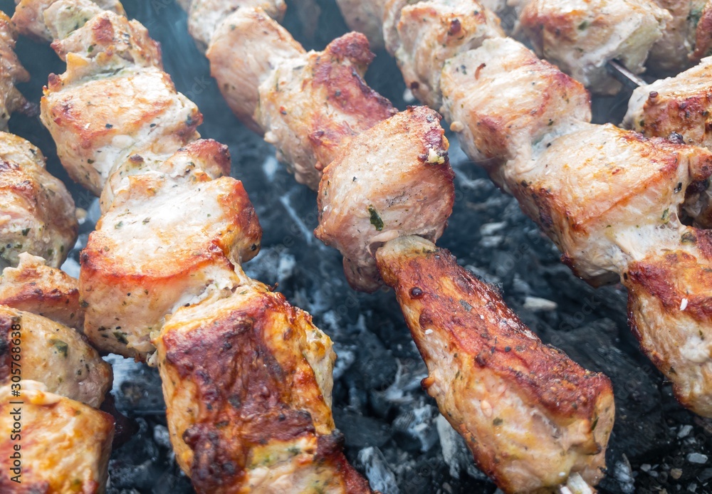 Close view on pork meat cooked outdoor on skewers
