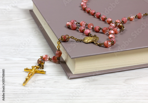 Rosary on a Book on White Wood Background