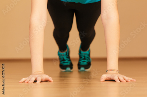 Stock photo of a young woman doing push-ups at home