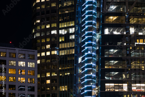 Modern urban scene of glowing lights and glass windows of skyscrapers at night