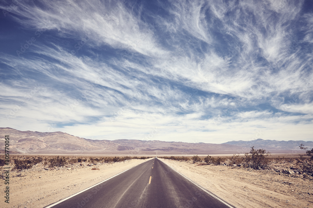 Desert road in Death Valley, color toning applied, USA.