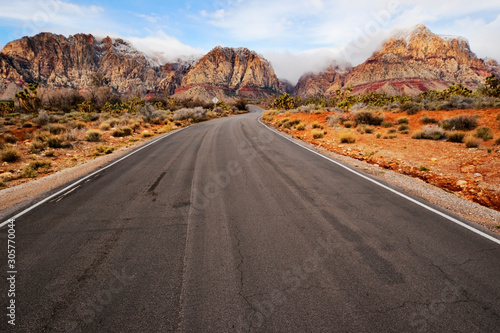 A two lane road running through a desert landscape