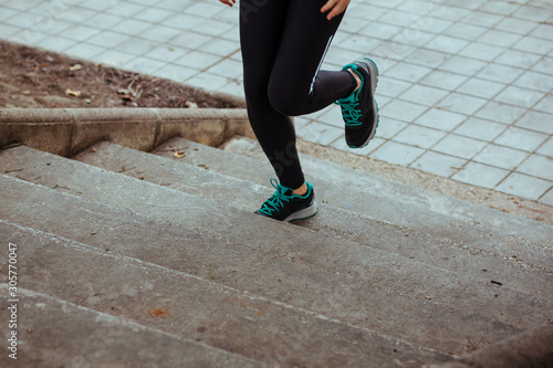 Stock photo of a young woman climbing stairs while running