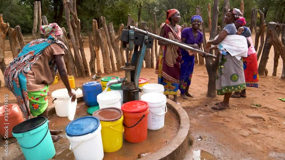 The plight for fresh water. Five woman and a baby drawing water into