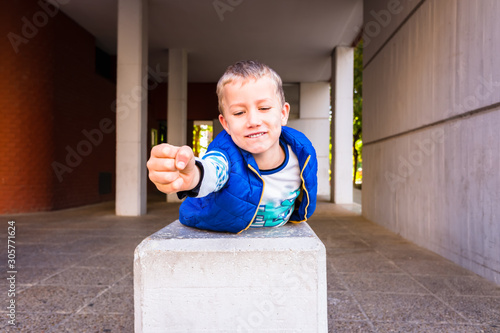 Brave boy with gesture of impetuousness and empowerment playing in the city. photo