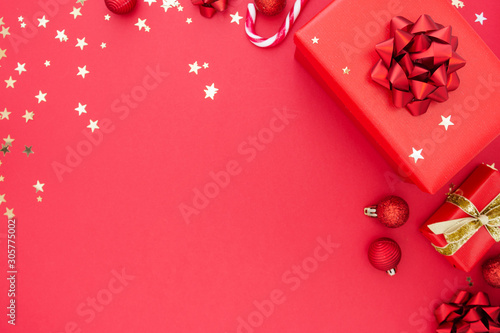 Red gifts presents on red background with ribbon bow and festive holiday decorations, copy space. Golden glitter. Valentine's day.