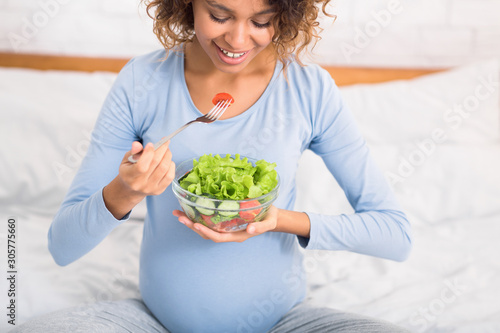 Pregnancy and nutrition. Expectant woman eating fresh salad