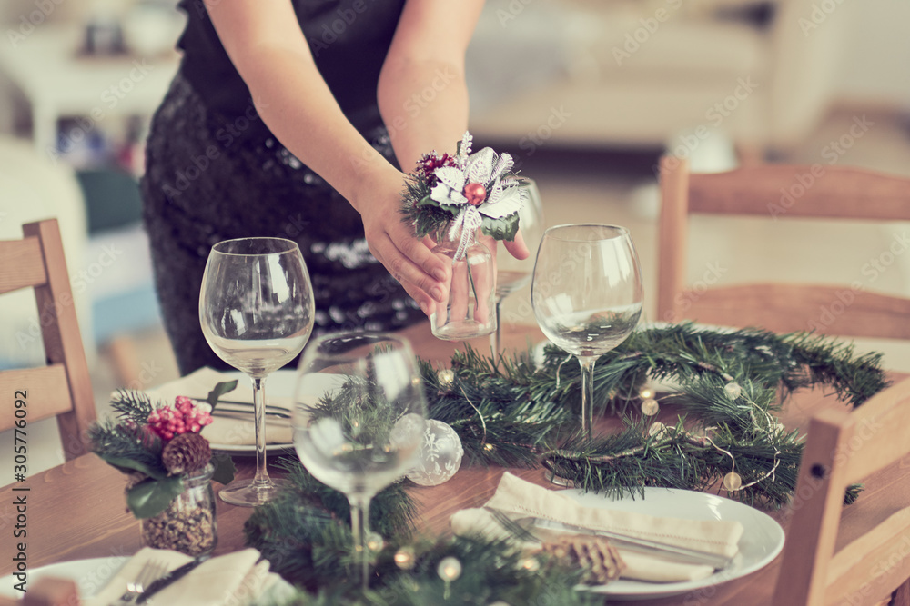 woman is waiting for guests and sets the table. festive laying table, preparation for christmas dinner.