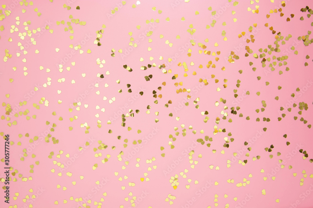 Abstract textured backgraund, golden heart shape glitter over pink background. Valentine's Day, love, birthday, party concept. Flat lay with copy space.