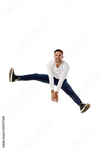 handsome young bearded man jumping. Full length portrait over white background