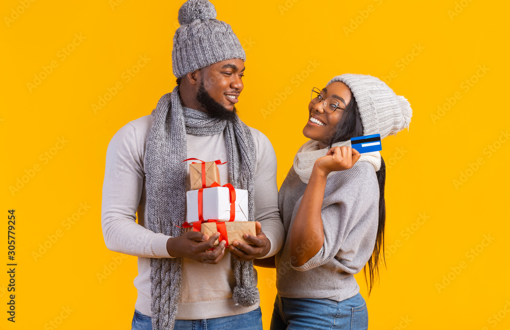 Black couple using credit card to buy xmas gifts Black couple using credit card to buy xmas gifts